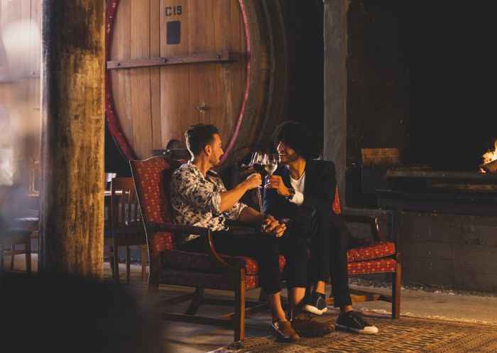Couple enjoying wine in front of a fireplace at Craigmoor Wines, Mudgee