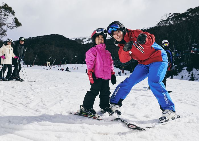 Young girl learning how to ski with an instructor at Thredbo in the Snowy Mountains