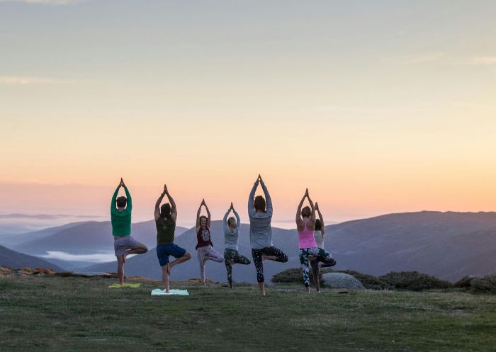 Friends enjoying sunrise yoga class outdoors with Jai Yoga in Thredbo