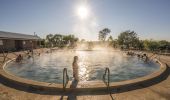 A woman steps into the steaming water at the Lightning Ridge Bore Baths, Lightning Ridge