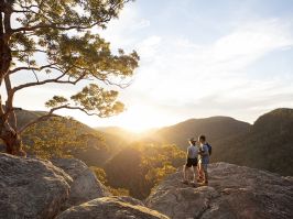 Couple watching a scenic sunset over the Hawkesbury Valley from the Vale of Avoca lookout in Grose Vale