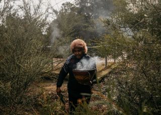 瑪格麗特坎貝爾在悉尼藍調角藍調角保護區舉行煙熏儀式，這是夢幻時光南部 X 體驗的一部分