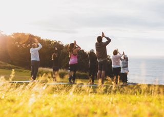 Frau genießt morgendliches Yoga mit Blick auf das Tal im Emirates One&Only Wolgan Valley