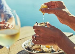 Couple enjoying fresh oysters and wine at Tuross Boatshed & Cafe, Tuross Head