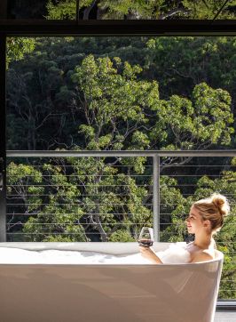 Woman relaxing in the bath with views at Spicers Sangoma Retreat, Bowen Mountain