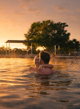 Couple enjoying a visit to the Lightning Ridge Bore Baths at sunset, Lightning Ridge