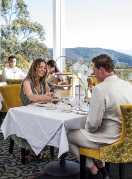 Couple enjoying a premium afternoon high tea at the Wintergarden restaurant within The Hydro Majestic Hotel, Medlow Bath