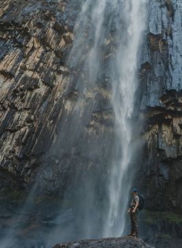 Person standing below the waterfall, Minyon Falls, Nightcap National Park - Credit: Lismore City Council