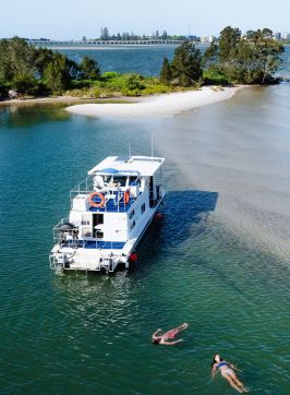  Aerial over waters with two people floating near houseboat, Forster Houseboat Hire, Forster