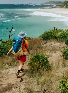 Friends hiking on a coastal track towards a beach, Pretty Beach - Credit: NPWS