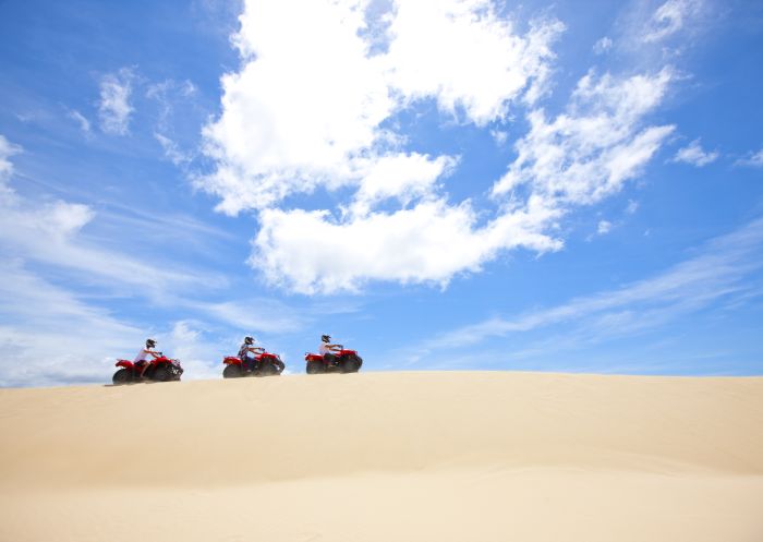 Quad bikes tour the Stockton Bight sand dunes in Port Stephens, NSW