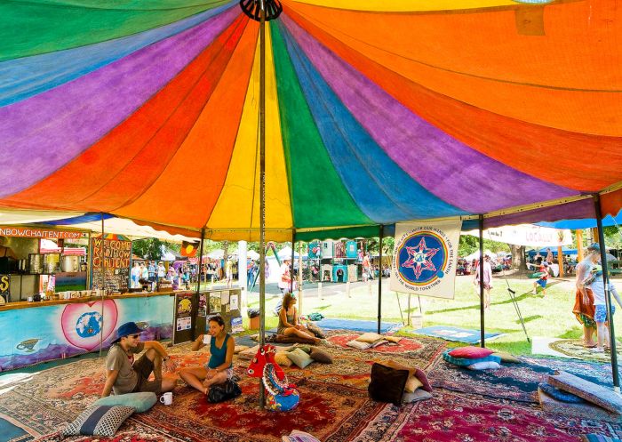 People relax under a colourful tent at Channon Craft Market, near Lismore