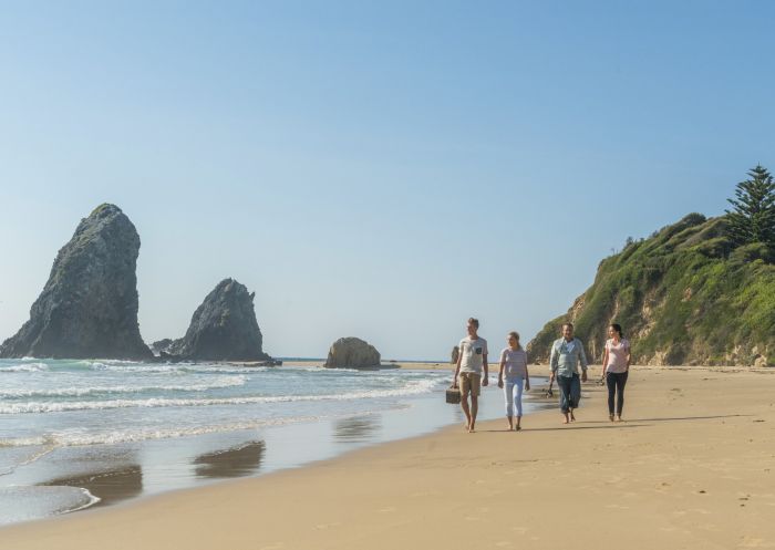 Family walking along the beach ready to fish at Glasshouse Rocks, Narooma