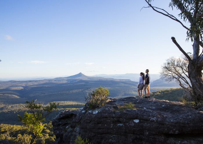 Couple enjoying panoramic views across to Pigeon House Mountain (Aboriginal: Didthul) in Moreton National Park