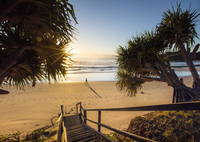 Woman enjoying a morning walk at Diggers Beach, Coffs Harbour