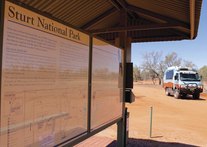 Tri State Safari's bus parked by an information sign in Sturt National Park