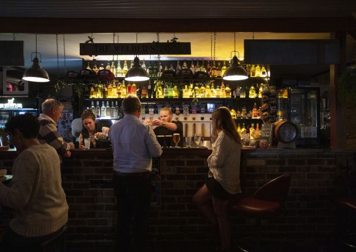 カントリーNSW、アーミデールにある「ザ・ウェルダーズ・ドッグ」で飲み物を振る舞われる人々