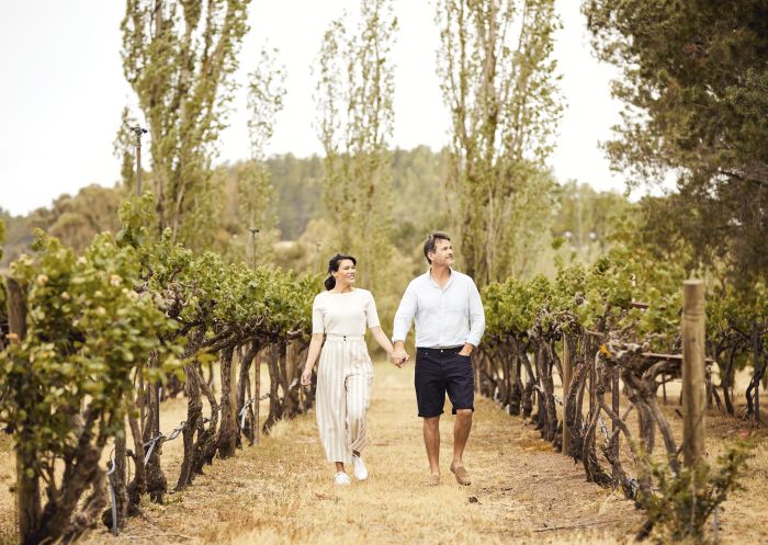 Couple enjoying a walk through the Helm Wines vineyard in Murrumbateman, Yass Area