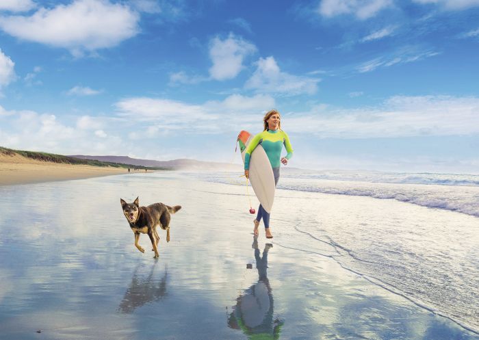Woman and her pet dog out for a morning surf at Shoalhaven Heads, South Coast