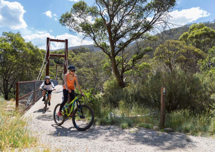 Mountain bikers travelling over a footbridge on the Thredbo Valley Track, Kosciuszko National Park