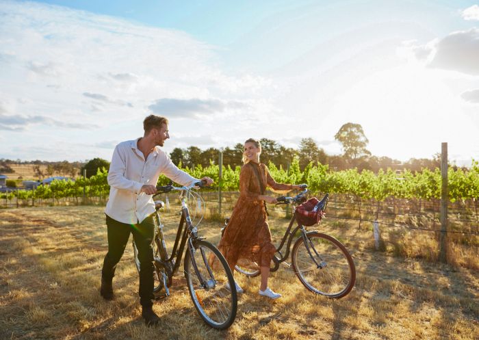 Couple enjoying a bike ride around the Clonakilla Wines vineyard in Murrumbateman, Yass Area