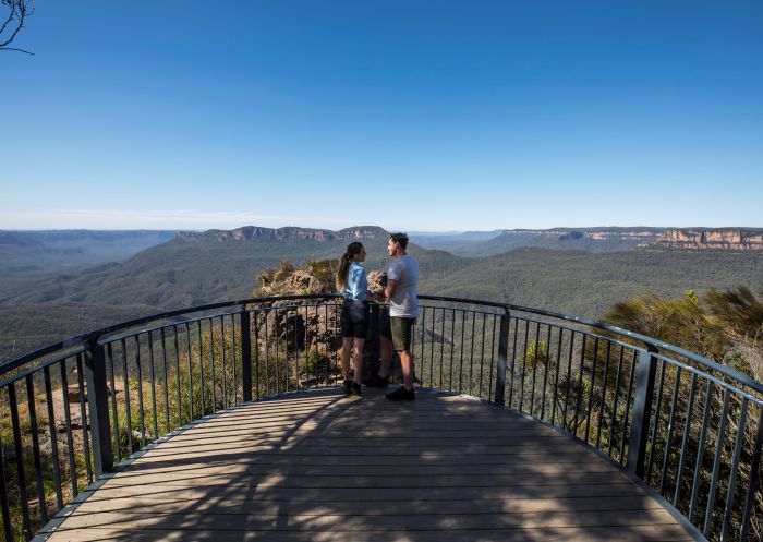 Couple enjoying views across the Jamison Valley to Mount Solitary along the Three Sisters Walking Trail, Katoomba