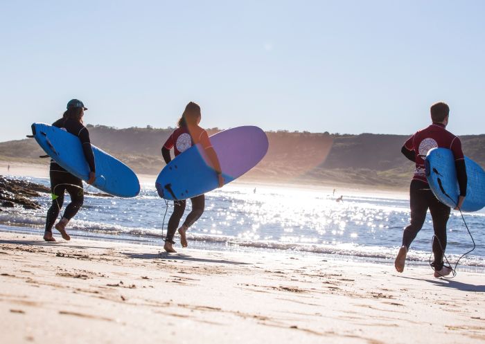 Couple learning to surf with Pines Surfing Academy Surf School at Killalea Beach ('The Farm'), Shell Cove, Shellharbour
