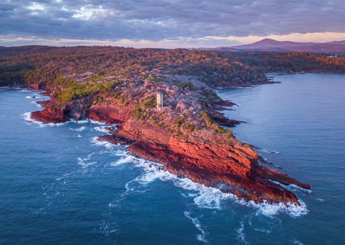 Sun rising over Boyd Tower on Red Point in the Beowa National Park, Edrom, South Coast