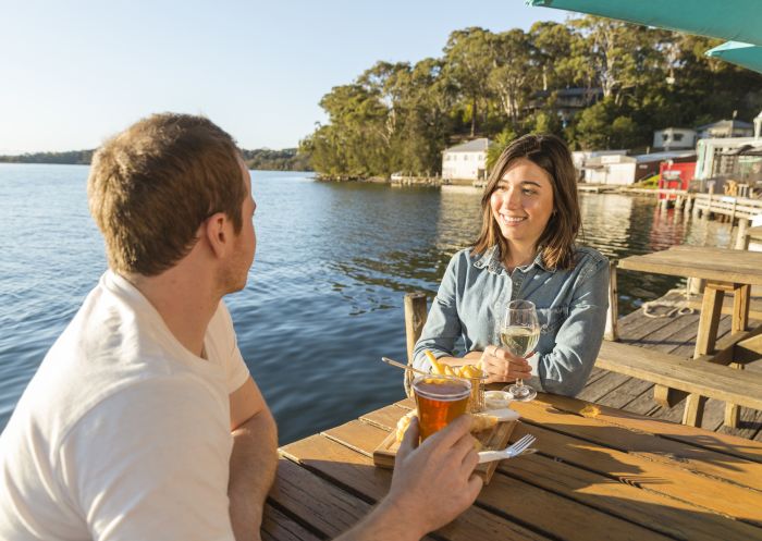 Couple enjoying fish and chips by the water at Tuross Boatshed & Cafe, Tuross Head, Batemans Bay Area, South Coast