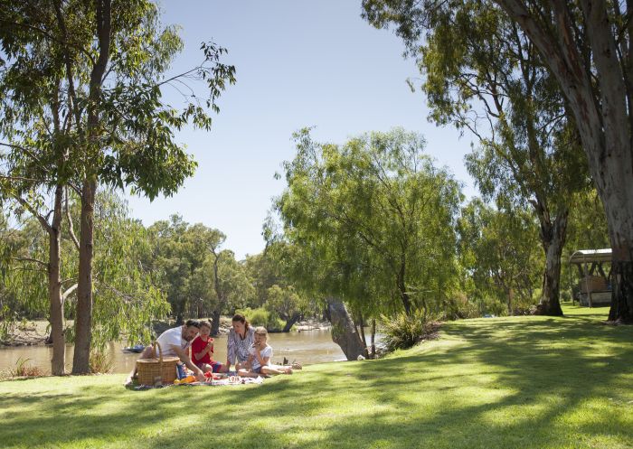 Family enjoying a picnic by the Edward River in Deniliquin, The  Murray, Country NSW