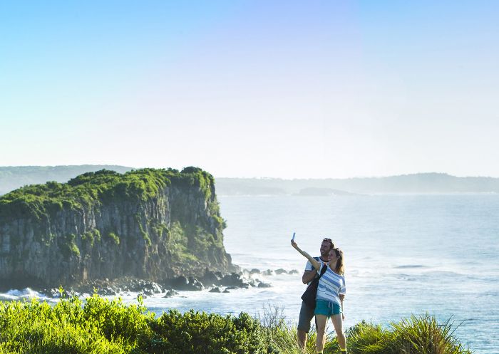 サウス・コーストカイアマのカイアマコースト ウォークで、ラングーン島を見下ろす美しいミナムラ岬で写真を撮るカップル