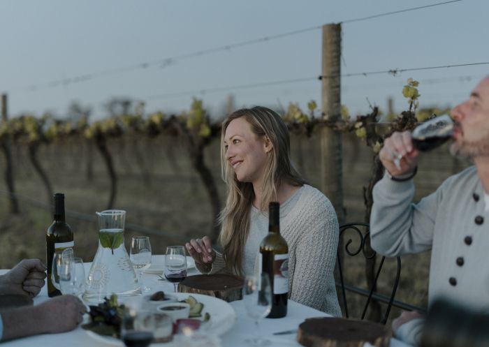 Couple enjoying food and drink outdoors in the vineyard at Restdown Wines, Barham.
