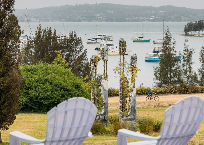Two white deck chairs with Lake Macquarie and Jamie North's sculpture in the background