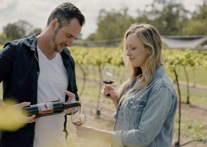Couple enjoying a glass of wine in the vineyards of Morrisons Riverview Winery and Restaurant in Moama, Country NSW