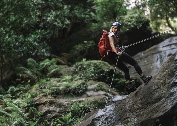 Woman abseiling Gap Creek Falls in Watagans National Park, Lake Macquarie