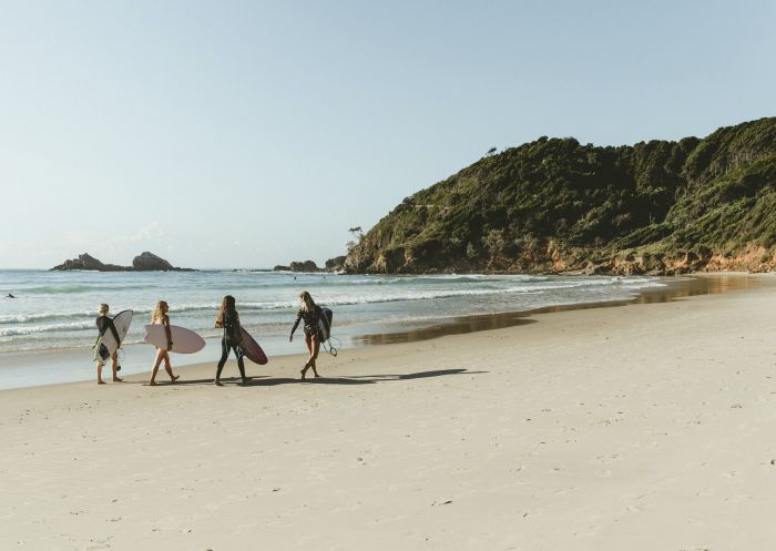 Surfers walking along Broken Head Beach in Byron Bay, North Coast