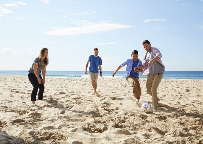 Friends playing beach soccer, Wollongong Beach
