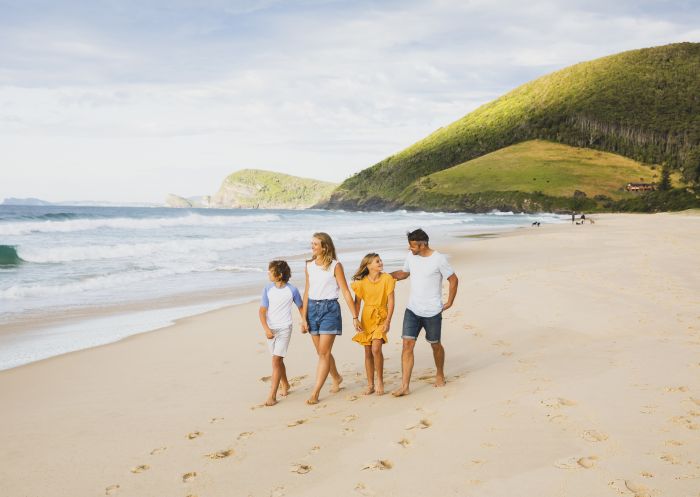 Family enjoying a walk along Blueys Beach in Pacific Palms, Forster & Taree Area