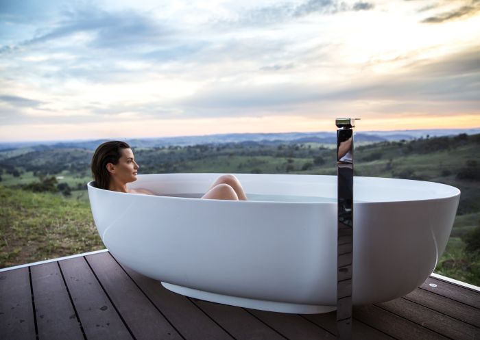 Woman enjoying a relaxing bath with scenic views across the Mudgee countryside from Sierra Escape, Piambong near Mudgee