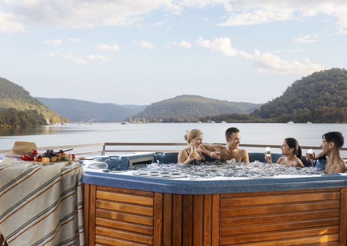 Friends relaxing on the Hawkesbury River aboard their houseboat in Wisemans Ferry
