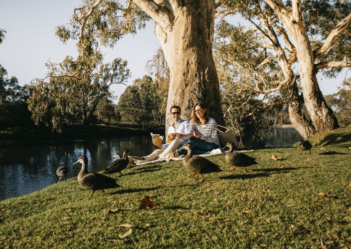 Couple enjoying a riverside picnic at Noreuil Park in Albury, The Murray