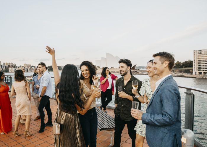 Friends enjoying rooftop drinks in The Rocks with views of Sydney Harbour