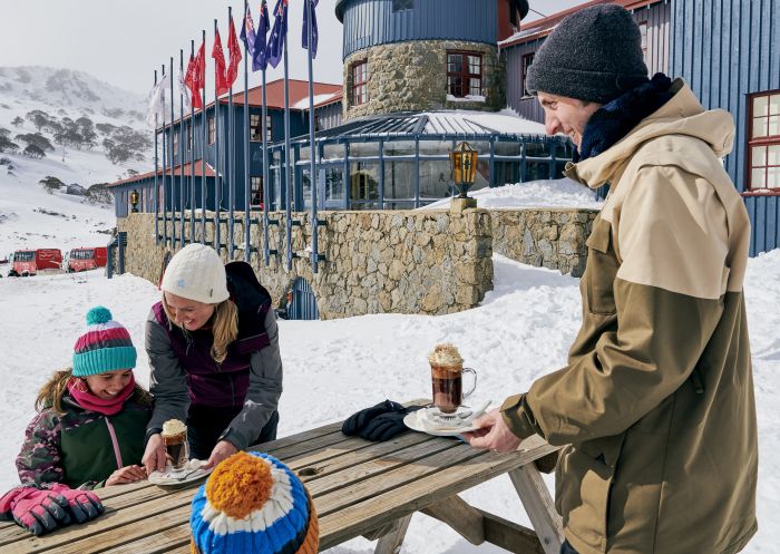 Family enjoying hot chocolates at Kosciuszko Chalet Hotel, Charlotte Pass in the Snowy Mountains