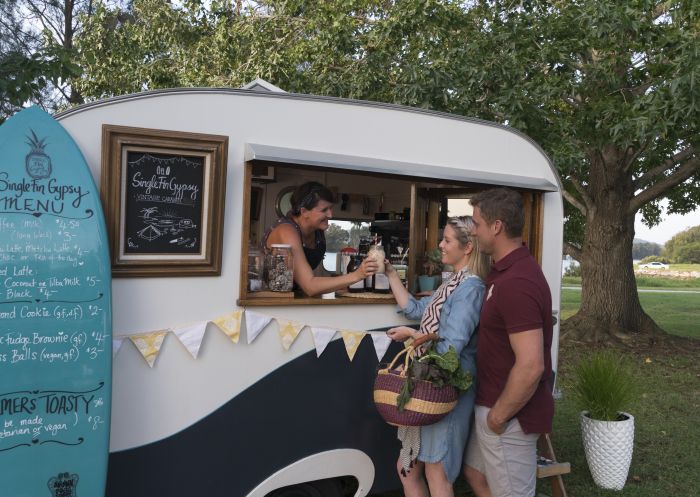 Couple buying a beverage from the Single Fin Gypsy caravan at the SAGE Farmers Market in Moruya