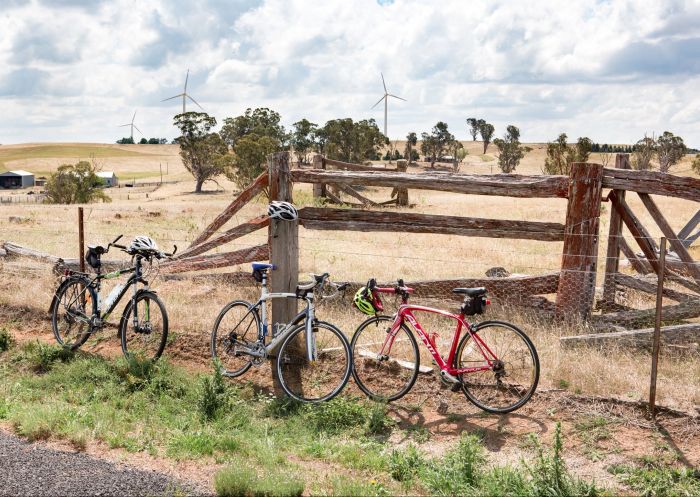 Three bicycles lean up against a wire fence beside an old timber cattle yard, Mulga Bicycle Tours in  Goulburn