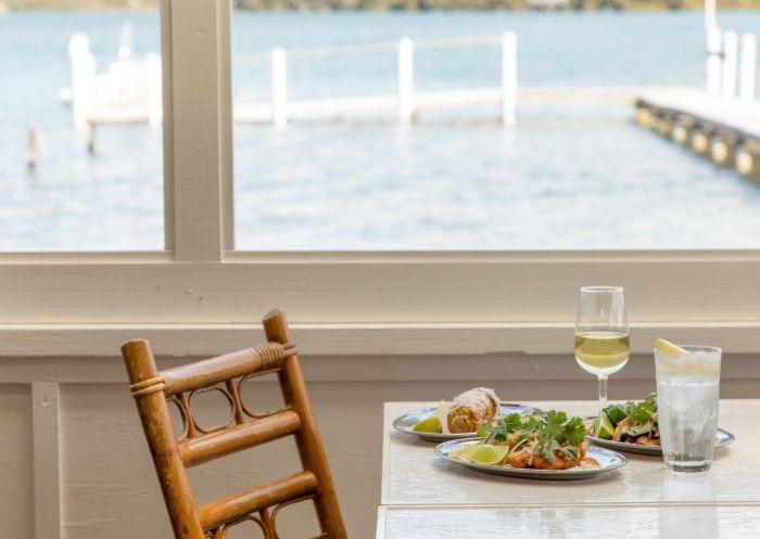 A table with starters looking out a window with water views at The Quarterdeck Narooma, Narooma - Credit: Honey Atkinson