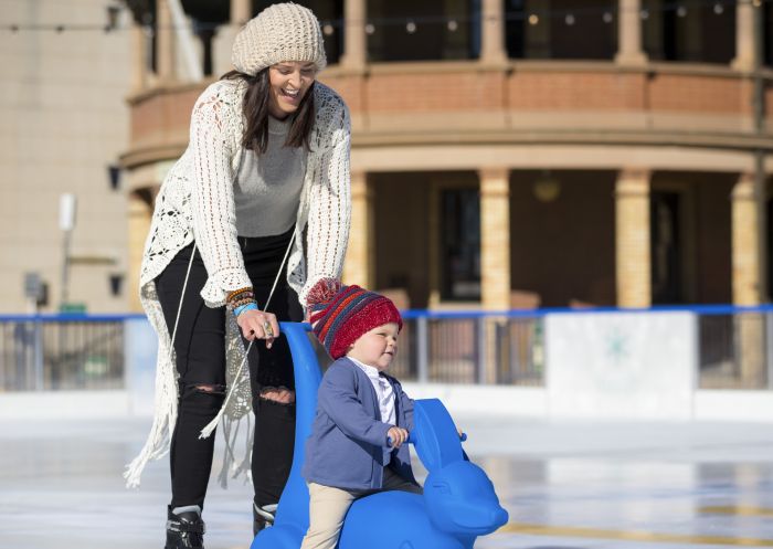 Mother and son enjoying a day on the ice rink at the Bathurst Winter Festival in Bathurst, Country NSW