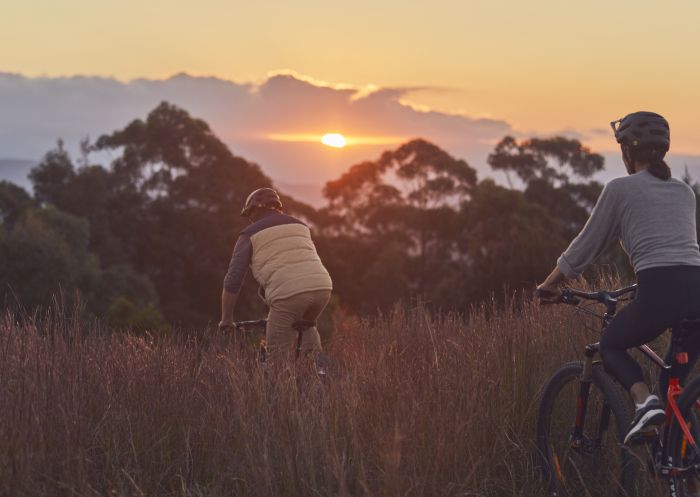 Couple enjoying an afternoon of mountain biking along the Big Bit Downhill track in Batemans Bay, South Coast