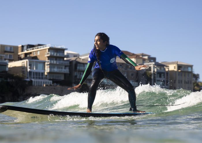 Woman enjoying a surf lesson with Lets Go Surfing in Bondi Beach, Sydney