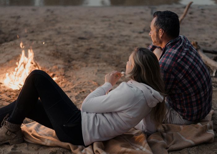 Couple enjoying a campfire by the Murray River, Echuca